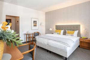 una habitación de hotel con una cama grande y una mesa en Hotel Moritz an der Elbe, en Zeithain