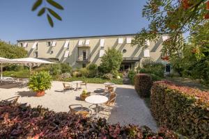 a courtyard with tables and chairs and a building at Hotel Moritz an der Elbe in Zeithain