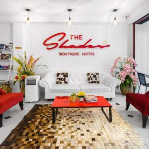 uma sala de estar com um sofá branco e uma mesa vermelha em The Shades Hotel 50 meter Beach Front em Praia de Patong