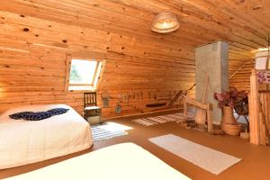 a bedroom with a bed in a wooden cabin at Sodyba “Rita” in Mėčiūnai