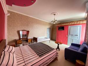 a bedroom with a large bed and a blue couch at Hostel Golden Fleece in Kutaisi