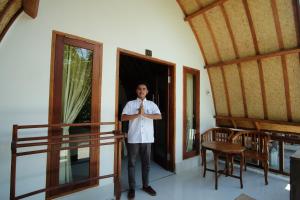Un uomo in piedi sulla porta di una casa di Warna Beach Hotel a Gili Trawangan Altre 43 foto