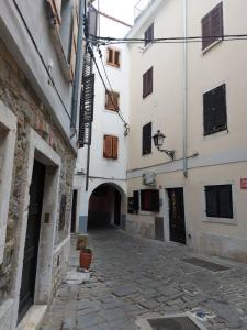 an alley with two white buildings and a street at Apartma Romeo in Piran