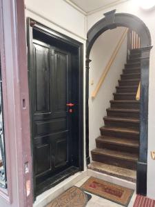 a black door in a room with a staircase at Apartma Romeo in Piran