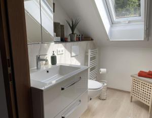a white bathroom with a sink and a toilet at Ferienwohnung am Kieferbach in Kiefersfelden