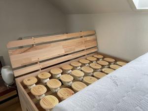 a bedroom with a bed with wooden headboard and cups at Ferienwohnung am Kieferbach in Kiefersfelden