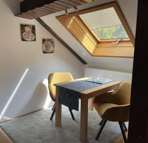 a room with a table and chairs and a skylight at Ferienwohnung am Kieferbach in Kiefersfelden