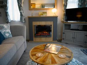 un soggiorno con camino e tavolino da caffè di Rose View a Newquay Altre 34 foto