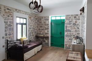 a bedroom with a bed and a green door at Elounda Art Stone House in Elounda
