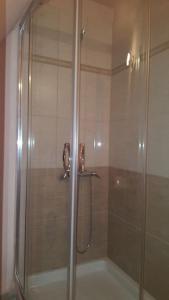 a shower with a glass door in a bathroom at Elounda Art Stone House in Elounda