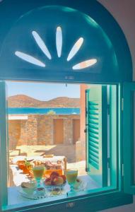 a window with a table with bowls of food on it at Elounda Art Stone House in Elounda +24 photos