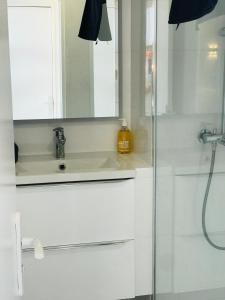 La salle de bains blanche est pourvue d'un lavabo et d'un miroir. dans l'établissement COSTA PLANA COLLECTION - Cap d'Ail - Monaco, à Cap d'Ail