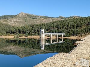 a reflection of a bridge in a body of water at El Molino de Candelario in Candelario
