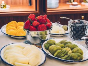 une table avec des assiettes de fruits sur une table dans l'établissement Iberostar Las Letras Gran Via, à Madrid