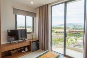 a hotel room with a television and large windows at JAP KARO in Tan An