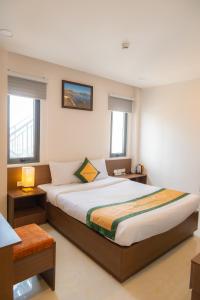 Tan An的住宿－JAP KARO，一间卧室设有一张大床和两个窗户。