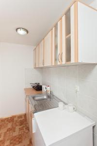 a kitchen with a white counter and a sink at Apartments Castanea in Sarajevo