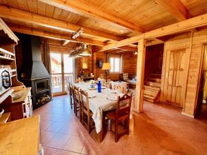 a large dining room with a table and a stove at Chalet de 3 chambres avec piscine partagee sauna et terrasse a Le Devoluy in Le Dévoluy