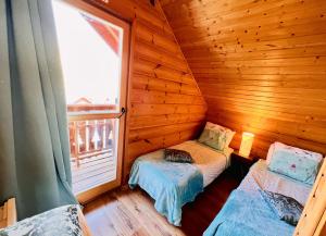 a small room with two beds in a wooden cabin at Chalet de 3 chambres avec piscine partagee sauna et terrasse a Le Devoluy in Le Dévoluy