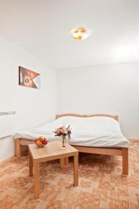 Un dormitorio con una cama y una mesa con flores. en Apartments Castanea, en Sarajevo