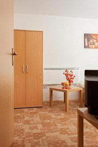 Habitación con armario y mesa con flores. en Apartments Castanea, en Sarajevo
