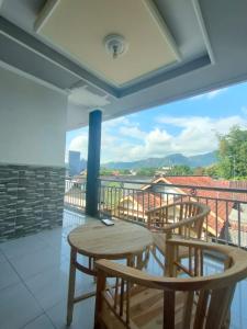 a balcony with a table and chairs and a view at Cahaya Homestay in Magelang