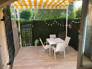 a patio with a table and chairs and an umbrella at BUNGALOW LA ISLA in Jávea