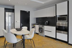 uma cozinha com mesa e cadeiras e uma cozinha com electrodomésticos em Lovely 2 bedroom rental unit close to the V&A Waterfront em Cidade do Cabo