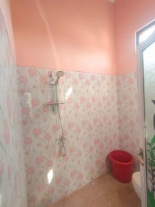 マゲランにあるCahaya Homestayのピンクの壁に花が飾られたバスルーム