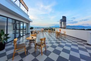 a patio with tables and chairs on a roof at JAP KARO in Tan An