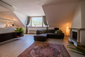 a living room with a couch and a fireplace at Theatre Lodge Attico teatro in Merano