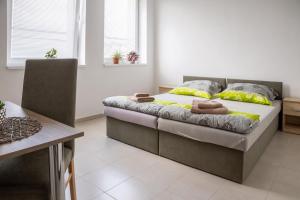 1 dormitorio con 1 cama con almohadas amarillas y grises en Motorest Farmárik en Topoľčany