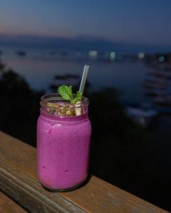 een metselaarspot gevuld met een roze drankje met een muntblad bij Dava Villa Ocean View in Nusa Penida