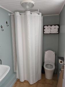uma casa de banho com uma cortina de chuveiro branca e um WC. em le cocooning marseillais bis em Marselha