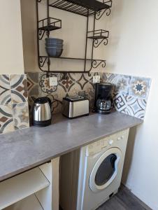 uma cozinha com uma máquina de lavar roupa debaixo de um balcão em le cocooning marseillais bis em Marselha