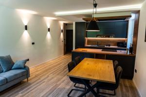 kuchnia i salon ze stołem i kanapą w obiekcie Modern apartment Leon w mieście Gozd Martuljek