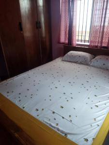 ein Schlafzimmer mit einem Bett mit Blumen darauf in der Unterkunft Hidden gem home stay -2 in Madikeri
