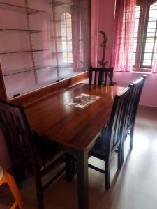 a dining room table with chairs and a wooden table at Hidden gem home stay -2 in Madikeri