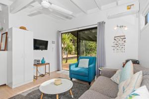 a living room with a couch and a table at Bayside Beauty - Matapouri Holiday Home in Matapouri