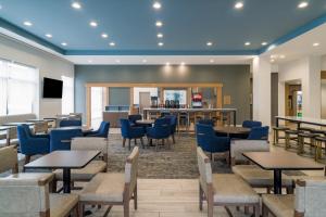 a restaurant with tables and chairs and a bar at Staybridge Suites - Louisville - Expo Center, an IHG Hotel in Louisville