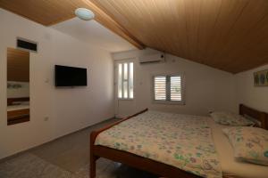 um quarto com uma cama e uma televisão de ecrã plano em Apartments with a parking space Nin, Zadar - 11402 em Nin