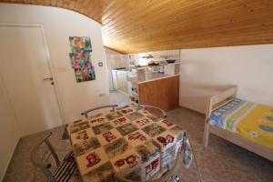 um quarto com uma mesa e uma cama e uma cozinha em Apartments with a parking space Nin, Zadar - 11402 em Nin