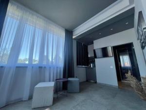una sala de estar con una gran ventana con cortinas blancas en Engels apartments - studio luminos en Cluj-Napoca