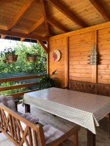 un tavolo e sedie in una veranda con soffitto in legno di Kuca za odmor Davidovic a Despotovac