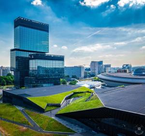 een groen dak op een gebouw met een stad op de achtergrond bij Katowice Gallery Center in Katowice