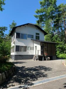 a white house with a gambrel roof at Sai's House Hakuba in Hakuba