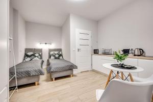 a room with a bed and a table and a kitchen at Central Platinum Apartments 25 in Rybnik