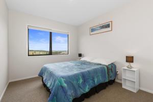 1 dormitorio con cama y ventana en Beach Haven - Karikari Peninsula Holiday Home en Karikari Peninsula