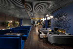 ロンドンにあるHotel AMANO Covent Gardenの青いソファと暖炉付きのロビー +37枚の写真
