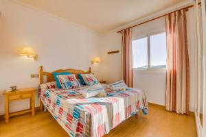 een slaapkamer met een bed en een raam bij Ideal Property Mallorca - Lago Miguel in Port d'Alcudia